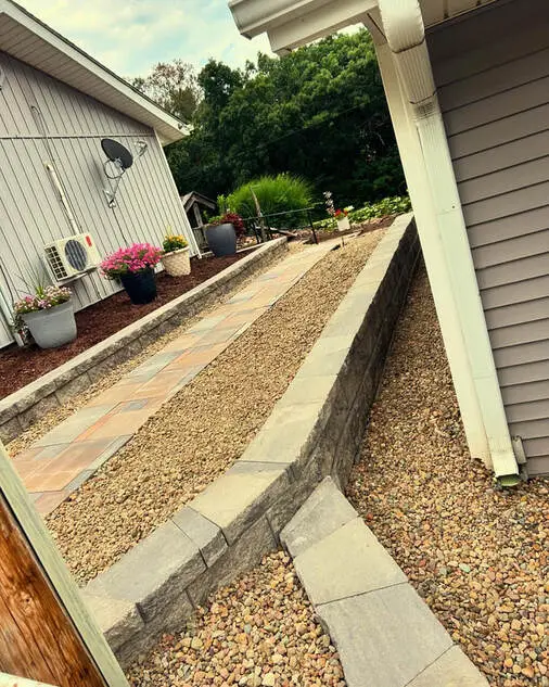 Rock border with block edging along a house